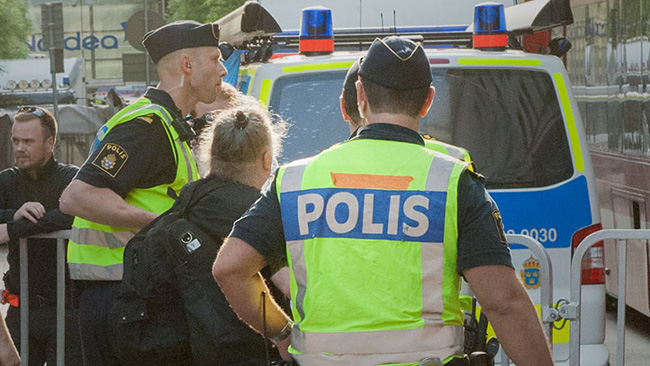 Här omhändertas vänsterpartiets Dror Feiler av polis. Foto: Sven Pernils