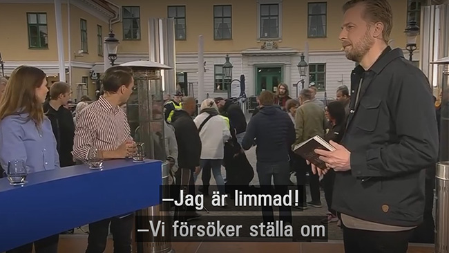 Här försöker aktivisten limma fast sig på scen under direktsändning